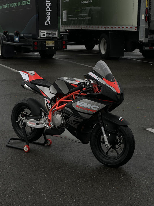 VMC GP12 Mini GP on a paddock stand beside the Mala Racing transport van